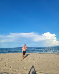 un hombre parado en una playa cerca del océano en LakeOsbornePearlfrom59dollarsfour6PersParty, 