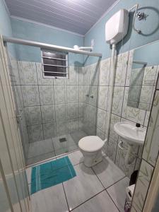 a bathroom with a shower and a toilet and a sink at Kitnet Camilóca 1 in Campo Grande