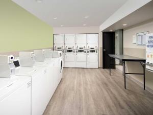 a laundry room with white cabinets and a table at WoodSpring Suites Medford near I-5 in Medford