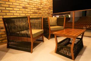 a group of chairs and a table and a table and a chair at Pousada Pedra da Pipa in Pipa