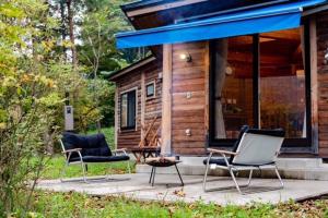 due sedie e un tavolo di fronte a una cabina di あさひプライム リゾートコテージ a Asahi