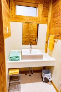 a bathroom with a white sink and a window at あさひプライム リゾートコテージ in Asahi