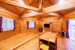 una grande stanza di legno con un tavolo di legno in una cabina di あさひプライム リゾートコテージ a Asahi