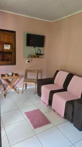 a living room with a couch and a tv at Casa Sonho de Verão in Ilha de Boipeba