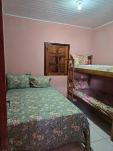 a bedroom with two beds and a bunk bed at Casa Sonho de Verão in Ilha de Boipeba