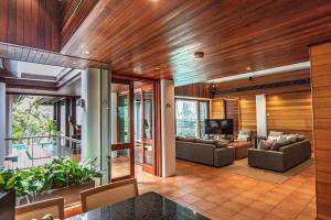 un soggiorno con due divani e una televisione di 17 Wharf Street - Main House & Bungalow a Port Douglas