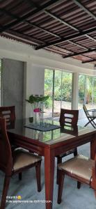 een eetkamer met een tafel, stoelen en ramen bij CALABAZO Casa MonoCai in Santa Marta