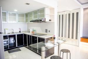 a kitchen with a glass counter top and a sink at UBN by Plush in Kuala Lumpur