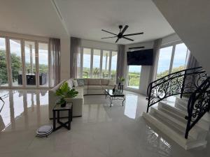 a living room with a couch and a ceiling fan at Luxury 4BR home with Infinity Pool, Jacuzzi & firepit in Playa Hermosa