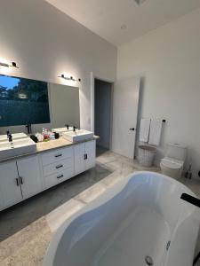 a large bathroom with two sinks and a tub at Luxury 4BR home with Infinity Pool, Jacuzzi & firepit in Playa Hermosa