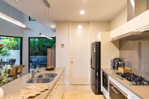 a kitchen with a sink and a stove top oven at Villa Amalfi - Port Douglas in Port Douglas