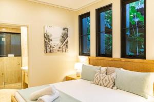 a bedroom with a bed and a bathroom with windows at Villa Amalfi - Port Douglas in Port Douglas +9 photos