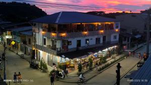Una calle de un pueblo por la noche con un edificio. en Hotel el Mono, en Nuquí