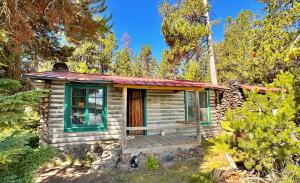 una piccola cabina in legno con portico nel bosco di Paulina Lake Lodge and Resort a La Pine