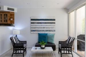 a living room with a couch and two chairs at Port Douglas Mirage Villa#423 in Port Douglas