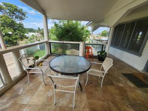 a patio with a table and chairs on a balcony at Dreaming Dawn in Tofoa