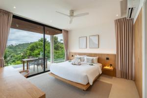 a bedroom with a large bed and a large window at Bay Villas Koh Phangan in Salad Beach +128 photos
