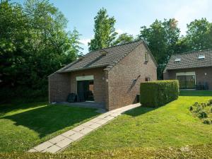 a brick house with a walkway in the yard at Holiday Home in South Limburg in Vijlen