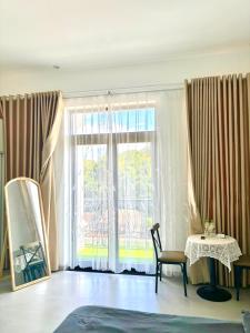 a room with a large window with a chair and a table at Thẩn Thơ Homestay in Hue +10 photos
