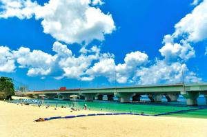 a bridge over a beach with people in the water at cuculu MAEJIMA 7F in Tomari