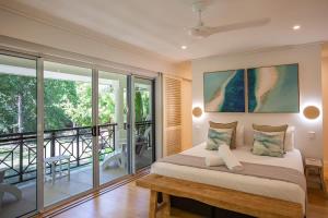 Un dormitorio con una cama y un balcón. en Sea La Vie - Port Douglas, en Port Douglas