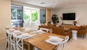 Un comedor con una mesa de madera y sillas blancas. en Sea La Vie - Port Douglas, en Port Douglas