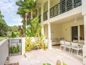 una casa con un patio con mesa y sillas en Sea La Vie - Port Douglas, en Port Douglas