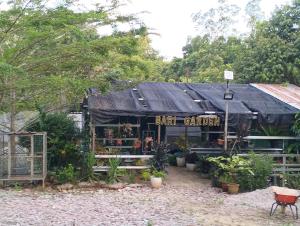 a barber shop with a black roof and a sign at Cassava Agrofarm Hostel in Sri Aman