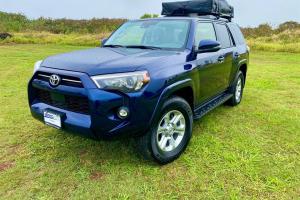 a blue suv parked in a field of grass at Simple & Fun Rooftop Camper Kauai SUV in Anahola