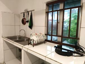 クチンにあるNatol Homestay - Venice 2 Samajaya Tabuan Tranquility Townshipのシンクと窓のあるキッチン +4枚の写真