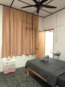 クチンにあるNatol Homestay - Venice 2 Samajaya Tabuan Tranquility Townshipのベッドと天井扇風機のある寝室