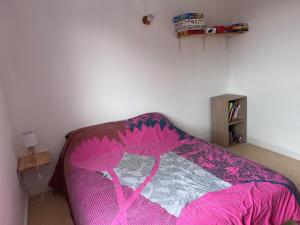 a bedroom with a bed with a pink blanket at Appartement spacieux pour 6 avec terrasse et parking privé - FR-1-814-152 in Super Besse