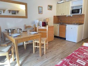 a kitchen with a wooden table and a kitchen with a table and chairs at Studio montagne 4 pers, Sud, Ski aux pieds - FR-1-330-592 in Risoul +11 photos
