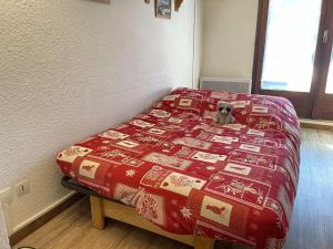 a bed with a dog sitting on top of it at Studio montagne 4 pers, Sud, Ski aux pieds - FR-1-330-592 in Risoul