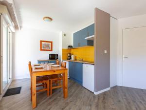 a kitchen with a wooden table and a dining room at Appartement Peyragudes pour 6 personnes avec balcon - FR-1-695-87 in Germ +5 photos