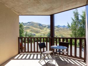 a balcony with a table and chairs and a view at Appartement Peyragudes pour 6 personnes avec balcon - FR-1-695-87 in Germ +4 photos