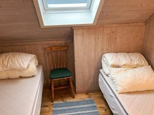 a room with two beds and a chair and a window at Seaside Retreat with Boats & Fishing in Beian