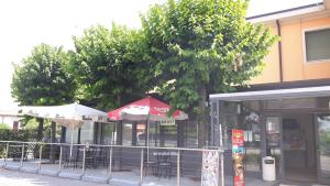 restauracja ze stołami i krzesłami przed drzewem w obiekcie Sony Affittacamere w mieście Desenzano del Garda