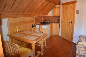 a small kitchen with a wooden table and chairs at Chalupa Ambra in Prachatice