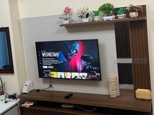 a flat screen tv hanging on a wall at Bayfront Suite in Pasay, Manila Near NAIA Terminal, PICC, Star City, MOA and US Embassy - Pet-Friendly, Free Pool, Wi-Fi & Netflix in Manila