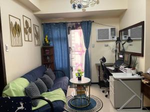 a living room with a blue couch and a desk at Bayfront Suite in Pasay, Manila Near NAIA Terminal, PICC, Star City, MOA and US Embassy - Pet-Friendly, Free Pool, Wi-Fi & Netflix in Manila