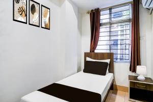 een kleine slaapkamer met een bed en een raam bij Super COLLECTION O SIXMILE GUWAHATI FORMERLY HOTEL GANGOTRI in Guwahati