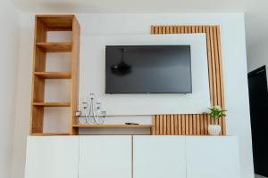 a television on top of a white cabinet in a room at Next to Basilica 3BR terrace wifi Punta Cana 30min in Higuey