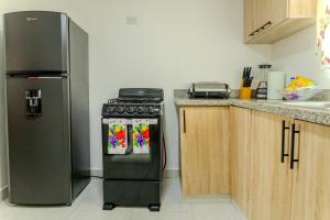 a kitchen with a stove and a refrigerator at Next to Basilica 3BR terrace wifi Punta Cana 30min in Higuey +22 photos