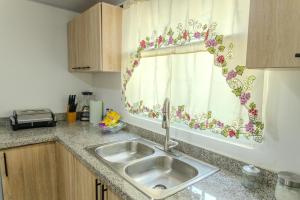 a kitchen counter with a sink and a window at Next to Basilica 3BR terrace wifi Punta Cana 30min in Higuey