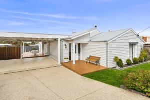 una casa blanca con un banco en una cubierta en Amos Court luxury, en Ocean Grove