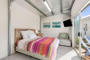1 dormitorio con 1 cama y TV en el balcón en Amos Court luxury, en Ocean Grove 12 fotos más