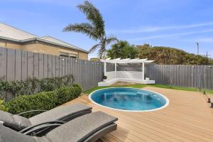 Un patio trasero con piscina y valla. en Amos Court luxury, en Ocean Grove