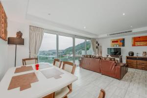 Ka RornにあるC236 Best Pool &Sea View 2BR Condo Prime Locationのテーブルと椅子のあるキッチンとリビングルーム