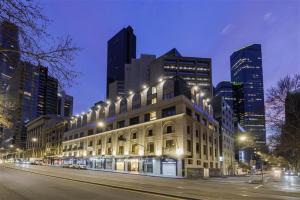a building with street lights in a city at night at Great Southern Hotel Melbourne in Melbourne